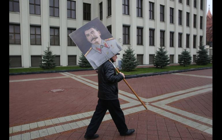Un miembro del partido comunista bielorruso sostiene un retrato de Stalin durante una concentración con motivo del 101 aniversario de la Gran Revolución Socialista de Octubre de 1917 en la plaza de la Independencia, en Minsk, Bielorrusia. EFE/T. Zenkovich