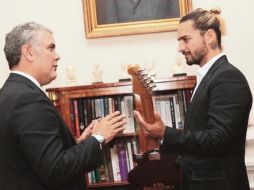 El cantante (derecha) le entrega una guitarra al presidente de Colombia, Iván Duque, durante su visita. ESPECIAL