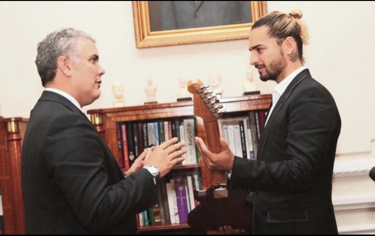El cantante (derecha) le entrega una guitarra al presidente de Colombia, Iván Duque, durante su visita. ESPECIAL