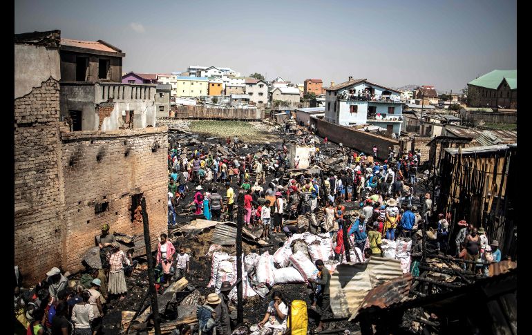 Habitantes intentan salvar sus pertenencias tras un incendio que consumió anoche una sección del mercado Anosibe en Antananarivo, Madagascar. AFP/M. Longari