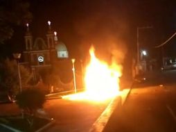 La población enardeció y decidió quemar una patrulla y otra más fue volcada, mientras que los uniformados se resguardaron en la azotea de la comandancia. ESPECIAL/