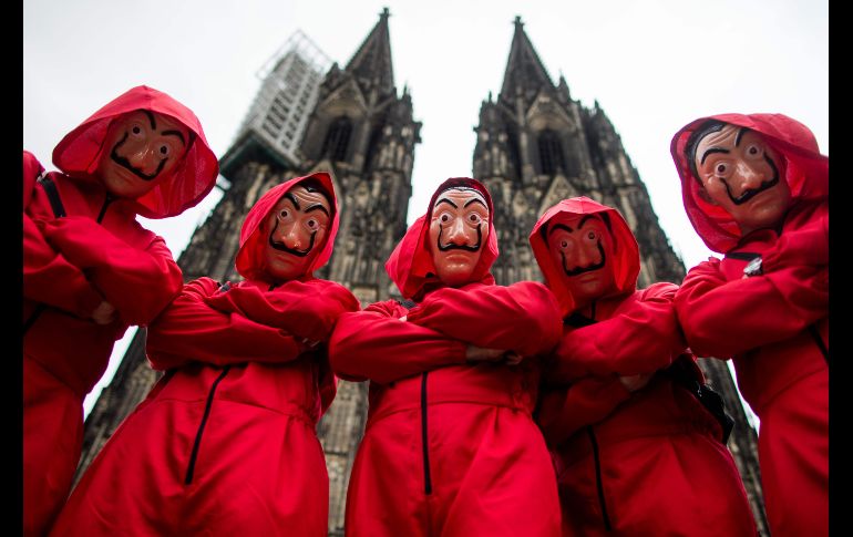 Personas asisten a las celebraciones del carnaval en Colonia, Alemania. Al fondo se ve la catedral de la ciudad. AFP/DPA/R. Vennenbernd
