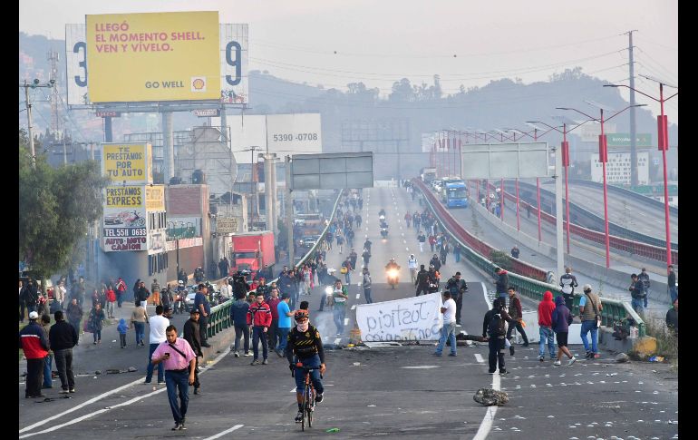 Personas cruzan un tramo de la autopista México-Pachuca durante un bloqueo vial. SUN/H. García