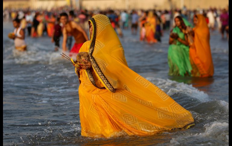 Hindúes oran en las aguas del mar Arábigo en Bombay, durante el festival Chhath Puja, en el cual se agradece al dios sol por mantener la vida en la tierra. AP/R. Maqbool