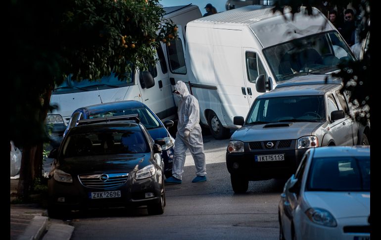 Policías investigan el sitio donde se halló un artefacto explosivo en Atenas, Grecia. El artefacto estaba frente a la casa de un fiscal de la corte de casación. AFP/A. Tzortzinis