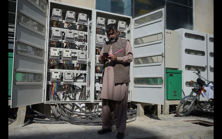 Muhammad Noshad, empleado de la compañía estatal de electricidad en Pakistán, realiza mediciones con su smartphone en un edificio comercial y así emitir los recibos para los clientes. AFP/A. Qureshi