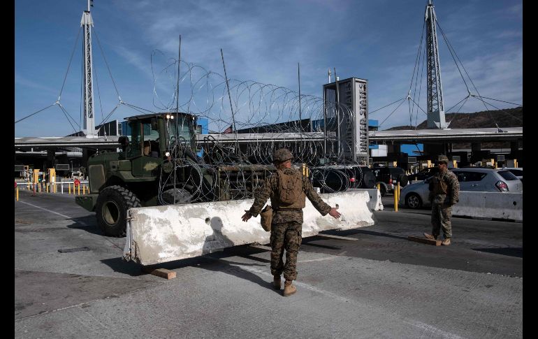 Una grúa mueve una barrera para bloquear carriles en el cruce de San Ysidro. AFP/G. Arias