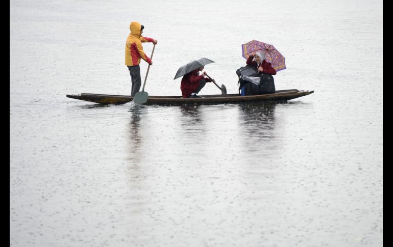 Estudiantes cachemires reman en el lago Dal de regreso a casa, durante un día frío y lluvioso en Srinagar, India. AFP/T. Mustafa
