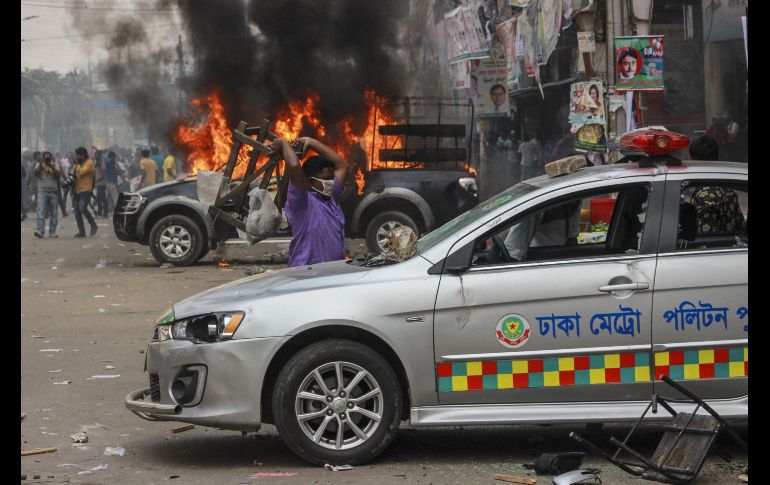 Activistas del Partido Nacionalista de Bangladesh incendian vehículos policiales durante un enfrentamiento tras  una marcha que bloqueó una calle en Dacca, Bangladesh. AFP