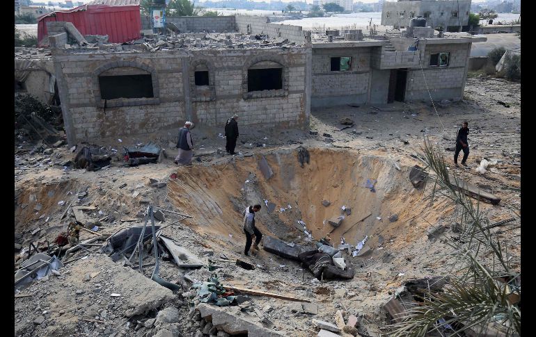 Palestinos inspeccionan un cráter provocado esta semana por un bombardeo aéreo israelí en Rafah, en la Franja de Gaza. AFP/S. Khatib