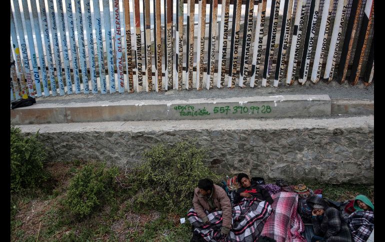 Centromericanos de la caravana migrante descansan en Tijuana junto a la valla fronteriza con San Diego, Estados Unidos. AFP/G. Arias