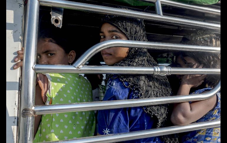 Mujeres rohinyás se ven en un vehículo policial en Kyauktan, Birmania, luego de que su bote fue arrastrado a la costa. El grupo intentaba llegar a Malasia. AFP/H. Htay