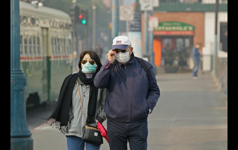 Una pareja que camina en San Francisco, California, se protege del humo provocado por los incendios forestales. AP/E. Risberg