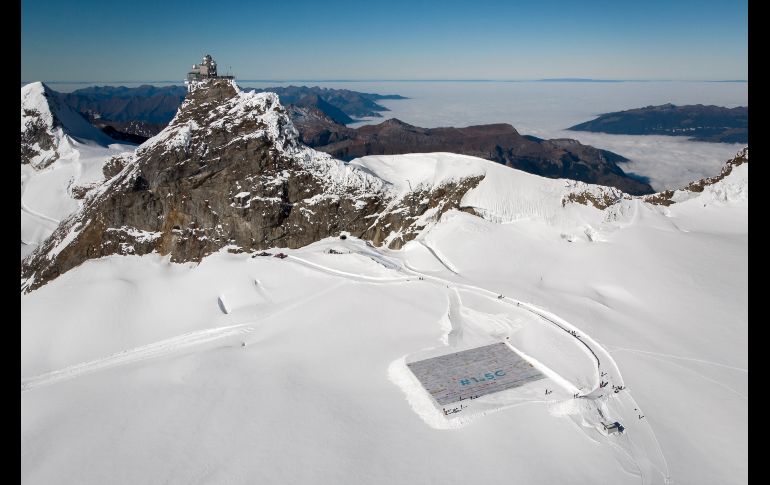 Una toma aérea muestra un collage gigante con 125 mil dibujos y mensajes de niños alrededor del mundo sobre el cambio climático se despliega en el glaciar Aletsch, en los Alpes suizos, en un acto organizado por la fundación WAVE. El mosaico de dos mil 500 metros cuadrados rompió el récord de postales gigantes. AFP/F. Coffrini