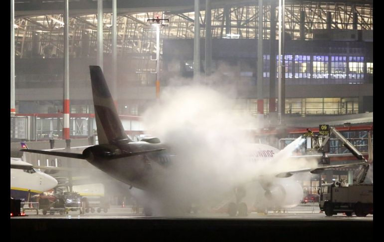 Labores para quitar el hielo de un avión de Eurowings en el aeropuerto de Hamburgo, Alemania, donde se registran temperaturas bajo cero. AFP/DPA/B. Marks