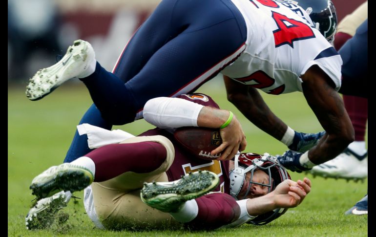 Alex Smith (abajo), mariscal de campo de los Redskins de Washington, sufre una fractura en el tobillo derecho durante una captura en partido de la NFL ante Texans de Houston, disputado en Landover. AP/P. Martinez