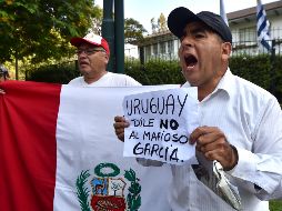 Manifestantes afuera de la embajada uruguaya en Lima exigen que no se le dé protección al expresidente García. AFP/C. Bouroncle