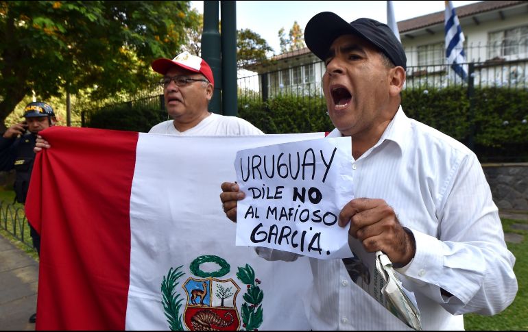 Manifestantes afuera de la embajada uruguaya en Lima exigen que no se le dé protección al expresidente García. AFP/C. Bouroncle