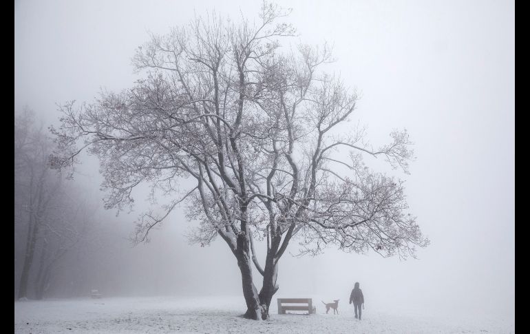 Dos personas pasean sobre la nieve en la colina de Buda en Budapest, Hungría. EFE/B. Mohai