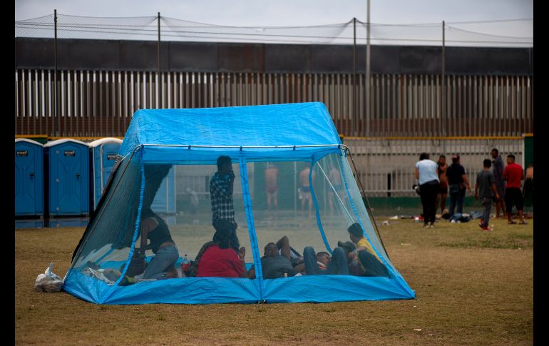 Centromericanos descansan en una casa de campaña dentro de un refugio.