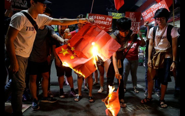 Estudiantes queman una bandera china en una protesta contra el presidente chino Xi Jinping, en una manifestación afuera del palacio presidencial en Manila, Filipinas. Xi  llegó el martes a Filipinas para su primera visita al país, en la que se rubricaron una veintena de acuerdos, como prueba de los estrechos lazos con la administración de Rodrigo Duterte. AP/A. Favila