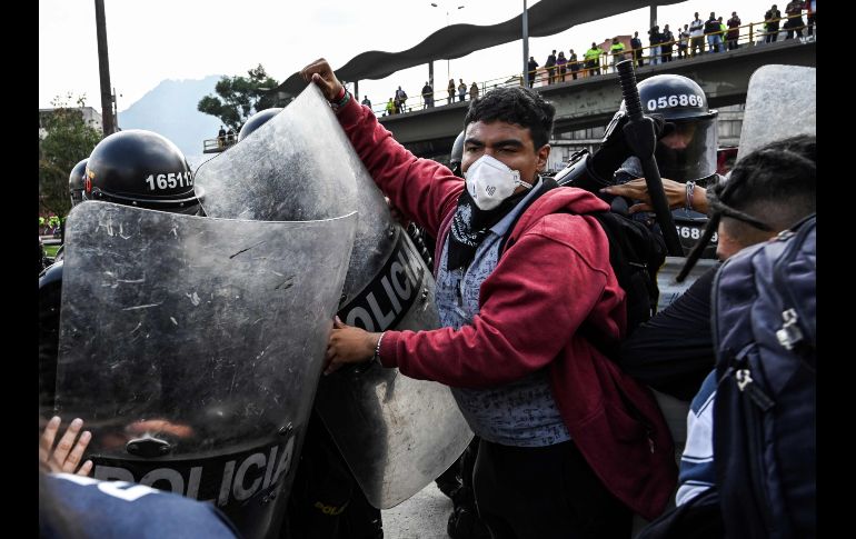 Universitarios se enfrentan con policías en Bogotá, Colombia, durante una protesta estudiantil en demanda de un incremento en el presupuesto para la educación y en contra de una reforma tributaria. AFP/J. Barreto
