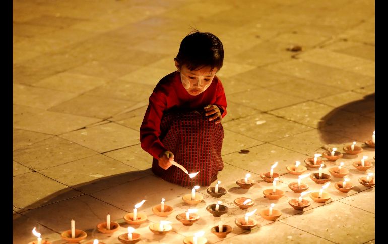 Un niño enciende unas velas en la víspera del Festival de Tazaungdaing en un templo budista de Rangún, Birmania. El festival es celebrado el día de luna llena de Tazaungmon, cuya procesión marca el final de la temporada de lluvias en el país. EFE/ N. Chan Naing