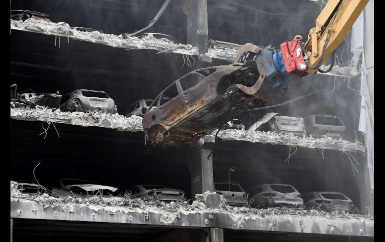 Una grúa retira un auto quemado de un estacionamiento en Liverpool, Inglaterra. El estacionamiento fue consumido por un incendio el 31 de diciembre del año pasado y apenas ahora comienzan los trabajos para demoler el edificio. AFP/P. Ellis