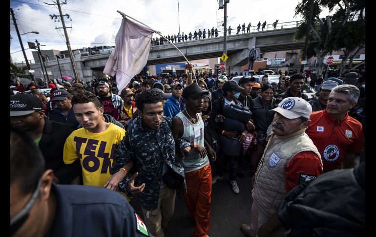 El grupo de centroamericanos marchó desde el albergue que ocupan en la zona norte de Tijuana hacia el punto fronterizo. AFP/P. Pardo