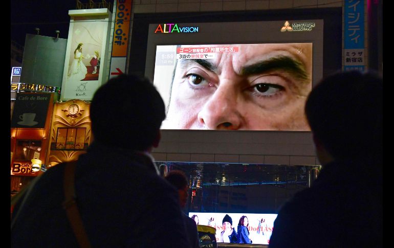 Peatones miran una pantalla en Tokio, Japón, de un noticiario que muestra a Carlos Ghosn. El consejo de administración de Nissan aprobó hoy el cese de Ghosn, su presidente, dos días después de su arresto por presuntas malversaciones. AFP/K. Nogi
