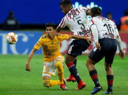 El jugador de Chivas Hedgardo Marín (c) disputa el balón con Raúl Torres (i) de Tigres. EFE/F. Guasco