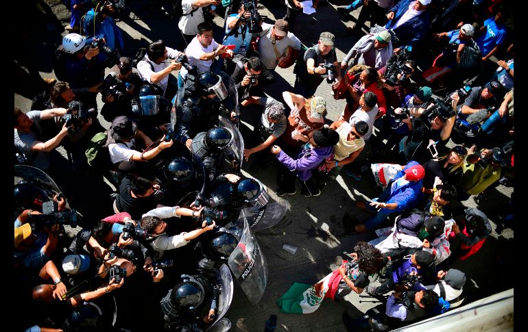 Policías federales en Tijuana, cerca del cruce de El Chaparral, bloquean al paso a migrantes. AFP/P. Pardo