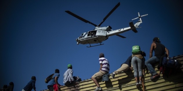Migrantes trepan muro fronterizo; EU lanza gas lacrim&oacute;geno