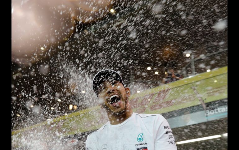 Lewis Hamilton,  piloto de Mercedes, celebra con champaña tras ganar el Gran Premio de Emiratos Árabes Unidos de Fórmula 1, disputado en Abu Dhabi. AP/H. Ammar