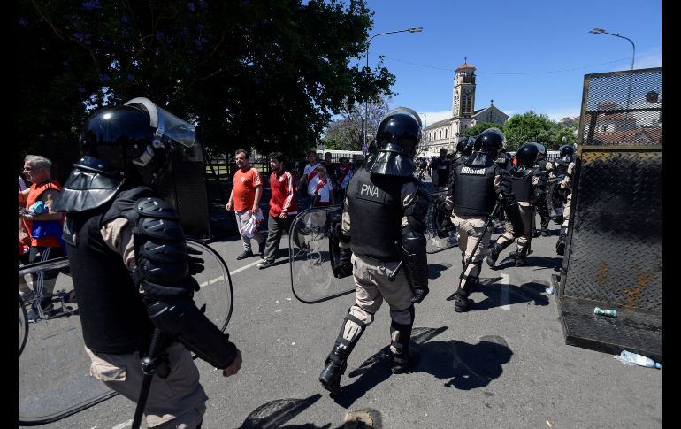 Fuerzas de seguridad vigilan mientras fans del River Plate salen del estadio Monumental en Buenos Aires, Argentina, luego de la cancelación del partido de vuelta de la final de la Copa Libertadores contra Boca Juniors. AFP/J. Mabromata