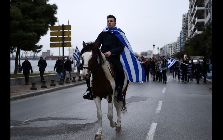 Un joven a caballo, envuelto en una bandera griega, lidera una protesta en Salónica Grecia. Cerca de mil estudiantes marcharon contra los esfuerzos del gobierno para poner fin a una disputa con la vecina Macedonia. AP/G. Papanikos