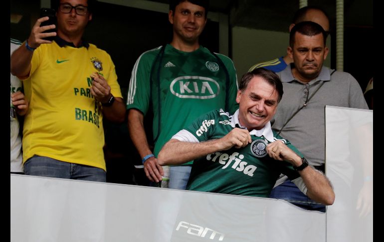 El presidente electo de Brasil, Jair Bolsonaro (c), vestido con la camiseta del club Palmeiras, saluda simpatizantes antes del inicio del partido entre Palmeiras y Vitória por el campeonato brasileño de futbol, disputado en Sao Paulo. EFE/S. Moreira