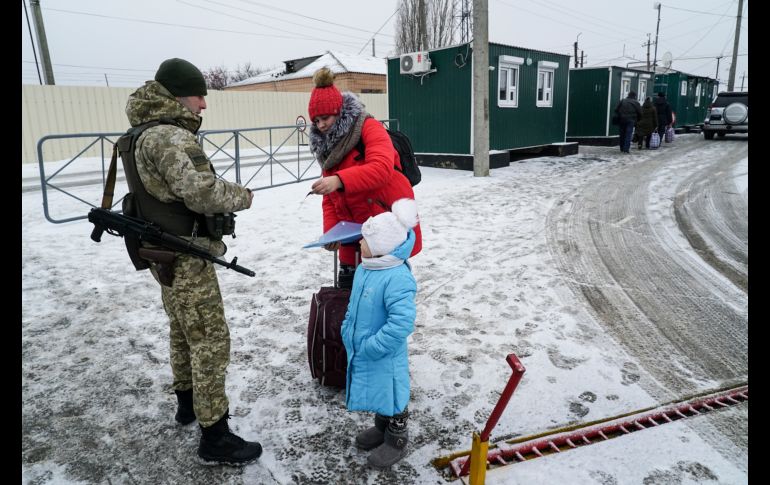Un guardia ucraniano revisa los documentos en Milove, cruce fronterizo con Rusia. AP/E. Maloletka