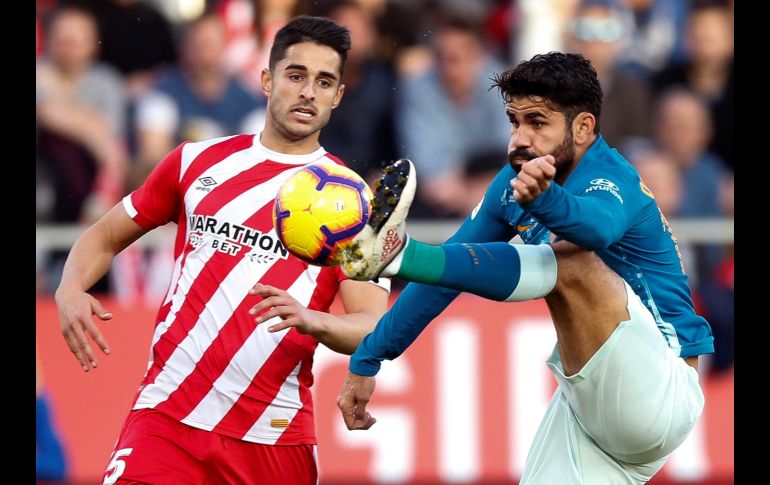 El delantero brasileño del Atlético de Madrid, Diego Costa (d), lucha por el balón frente al defensa del Girona, Juanpe Ramírez (i), durante un partido de la liga española disputado en Montilivi. EFE/ E. Fontcuberta