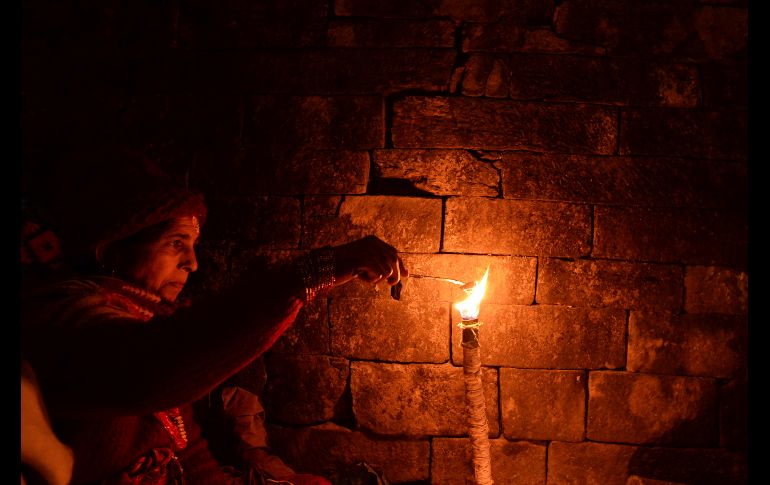 Un hindú nepalí enciende una lámpara de aceite en memoria de sus familiares fallecidos, durante el festival Bala Chaturdashi en Katmandú, Nepal. AFP/P. Mathema