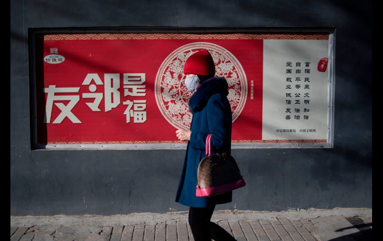 Una mujer pasa junto a una propaganda que elogia el patriotismo chino en Pekín. AFP/F. Dufour