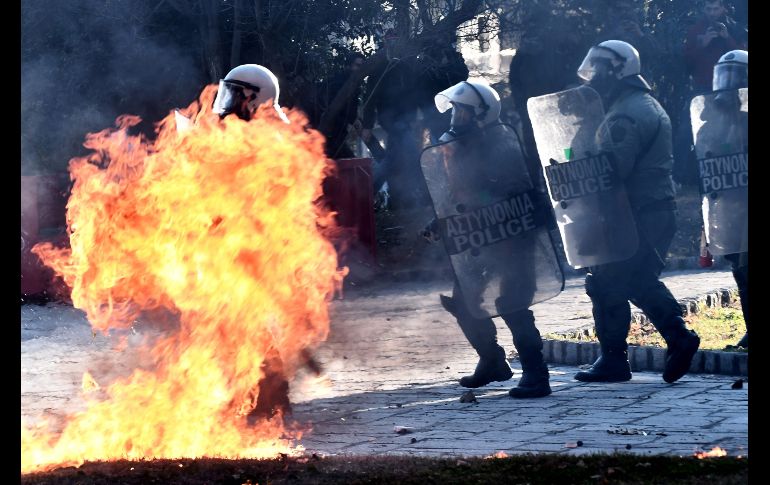 Bombas molotov estallan junto a policías antimotines en Atenas, Grecia, en una manifestación por el décimo aniversario del tiroteo en que murió un adolescente y desencadenó disturbios en el país. AFP/S. Mitrolidis