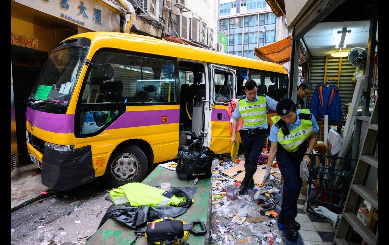 Personal de emergencias trabajan en el lugar del accidente de un autobús escolar en Hong Kong, China. Al menos cuatro personas han muerto y otras 11 han resultado heridas después de que un autobús invadiera la acera cuando el vehículo, sin conductor en ese momento, cayó calle abajo. EFE