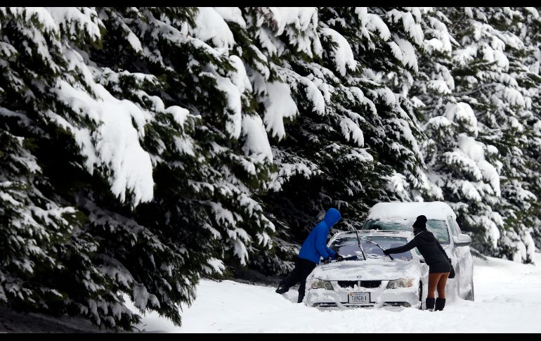 Habitantes retiran nieve de un carro en Richmond, Virginia. AP/S. Helber