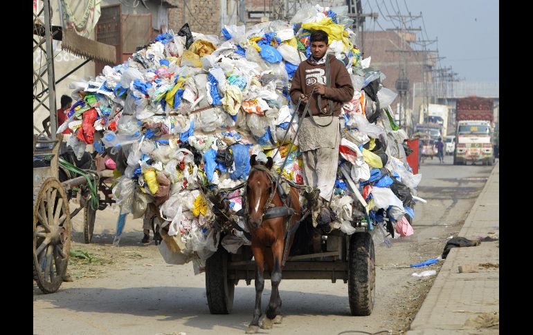 Un joven traslada bolsas de plástico desechadas en Lahore, Pakistán. AFP/A. Ali