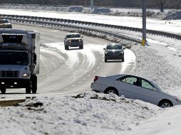 Conductores pasan cerca de un auto abandonado en la nieve tras un choque, en Carolina del Norte. AP/C. Burton