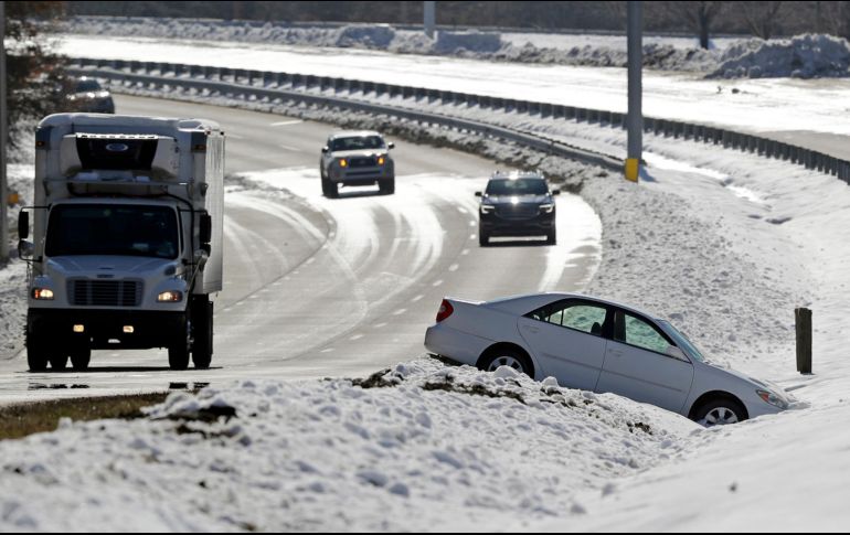 Conductores pasan cerca de un auto abandonado en la nieve tras un choque, en Carolina del Norte. AP/C. Burton