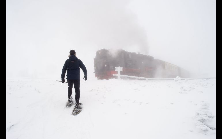 Un técnino del clima cruza las vías del tren rumbo a su trabajo, en la estación del Servicio Metereológico Alemán en la montaña nevada de Brocken, en la población de Schierke. AFP/DPA/K. Gabbert