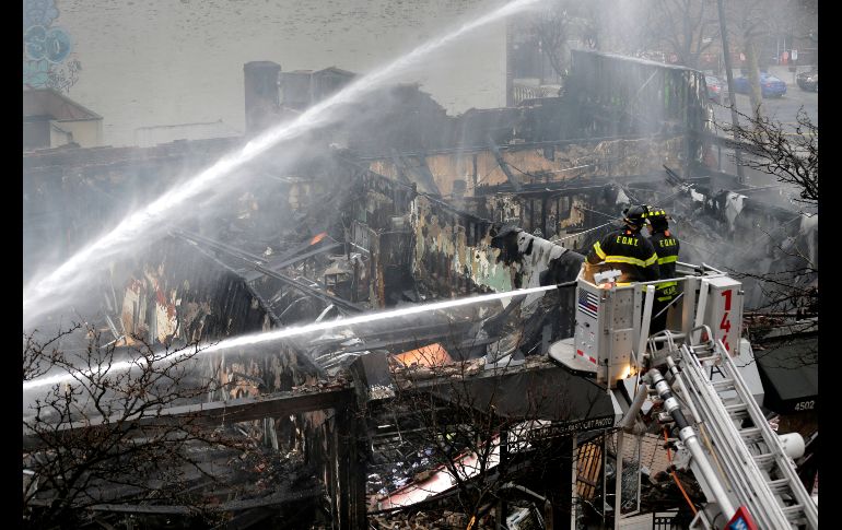 Bomberos trabajan para apagar un incendio que afecta a varios negocios en la zona de Queens, en Nueva York. AP/S. Wenig