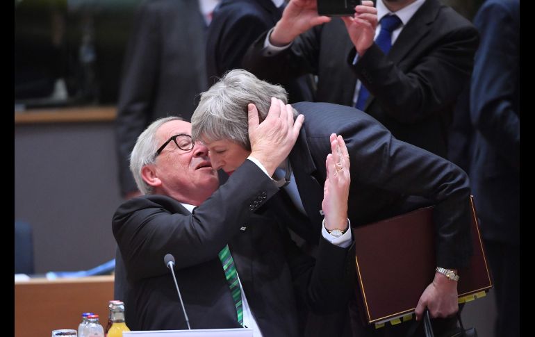 El presidente de la Comisión Europea, Jean-Claude Juncker, le susurra algo a la primera ministra británica, Theresa May, que llega a una cumbre en Bruselas, Bélgica, para tratar el 